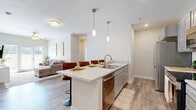 Located at 4412 Belleview Ave in Kansas City, MO, this thoughtfully designed single-floor unit offers four bedrooms and four bathrooms within a well-utilized, efficiently laid-out floor plan. The open-concept kitchen serves as a central highlight, featuring a large island with a quartz countertop, a double sink, stainless steel appliances including a range, microwave, and dishwasher, gray shaker-style cabinetry, and pendant lighting. Bar-height seating along the island makes it ideal for casual dining and entertaining. The kitchen flows seamlessly into the living room, which is appointed with wood-look flooring, a ceiling fan, and a glass door providing natural light and outdoor access. Each bedroom offers plush carpeting and ample space, with the rooms individually accessible off shared corridors. The bathrooms are clean and contemporary, featuring vessel sinks, gray vanities with under-cabinet storage, tile flooring, and walk-in showers. A wall-mounted mini-split HVAC unit ensures individual climate control. The neutral color palette, recessed lighting, and modern fixtures throughout lend the space a cohesive, move-in-ready aesthetic suited for both individual and shared living arrangements.
