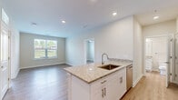 Located at 1330 Nashville Pike in Gallatin, Tennessee, this 2-bedroom, 2-bathroom single-floor residence offers a thoughtfully designed layout with contemporary finishes throughout. Light wood-look flooring runs seamlessly across the entire space, contributing to a clean, cohesive aesthetic.

The kitchen is a standout feature, showcasing white shaker cabinetry, granite countertops, a peninsula with a sink ideal for casual dining or prep work, and a full suite of stainless steel appliances including a refrigerator, range, microwave, and dishwasher. Recessed lighting illuminates the space effectively.

Both bedrooms are comfortably sized, with the primary bedroom offering a dedicated closet. Each room features ceiling fans and windows with blinds that invite natural light and outdoor views. The neutral wall tones create a calm, versatile backdrop.

The two bathrooms are finished with white subway tile surrounds on the tub/shower combinations, granite-topped white vanities with brushed nickel hardware, and wood-look flooring that mirrors the rest of the home. The primary bathroom includes access to a walk-in closet with built-in shelving.

Two closets provide ample storage throughout the residence. The overall design is modern, clean, and move-in ready, making it an efficient and attractive space in the Gallatin community.