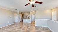 Located in Austin, TX, this well-appointed 2-bedroom, 2-bathroom home offers a thoughtfully designed open-concept layout across a single floor. The living room is a bright, welcoming space featuring light hardwood-style flooring, crown molding, a ceiling fan with light fixture, and multiple windows that flood the area with natural light and offer views of the surrounding neighborhood.

The kitchen flows seamlessly from the living area and is a standout feature of the home. It is equipped with stainless steel appliances — including a refrigerator, range, microwave, and dishwasher — complemented by granite countertops, a kitchen island with an undermount sink, crisp white cabinetry, and built-in open shelving, creating an efficient and stylish cooking space.

Both bedrooms are carpeted for comfort, each featuring a ceiling fan, natural light from windows with blinds, and neutral-toned walls. The spacious primary bedroom offers a comfortable retreat. The two bathrooms are finished with granite-topped white vanities and hardwood-style tile flooring, with one bathroom featuring a tub/shower combo. A dedicated closet adds additional storage convenience. Carpeted stairway access is also present within the home.