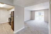 This single-floor residence offers a practical and comfortable layout designed for everyday living. The open living area is finished with plush carpeting and neutral-toned walls, creating a bright and welcoming atmosphere. A large sliding glass door floods the living space with natural light and provides access to the outdoors. The textured ceilings and clean white baseboards add a consistent finish throughout.

The kitchen is efficiently designed with light wood-style flooring, white cabinetry, granite-style countertops, and black appliances including a refrigerator, gas range, and dishwasher. It opens conveniently toward the main living and hallway areas, supporting easy flow through the unit.

A carpeted hallway connects the living areas to the private spaces, which include bedrooms with ample floor space and neutral finishes. Closet doors are visible along the corridor, offering plentiful storage options.

The bathrooms are updated with white vanity cabinetry, granite countertops, undermount sinks, and full tub-shower combinations. Each bathroom features large mirrors that enhance the sense of space and light. The light wood-style flooring in the bathrooms and kitchen provides a cohesive contrast to the carpeted areas throughout the rest of the unit.