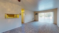 Located at 4260 Rocky River Dr in Cleveland, Ohio, this single-floor unit offers a straightforward, functional layout designed for comfortable everyday living. The living area is generously proportioned, featuring wall-to-wall carpeting in a neutral tone that carries throughout the main spaces. A ceiling fan overhead provides airflow, while a wall-mounted air conditioning unit ensures climate control year-round. Vertical blinds frame a sliding glass door that floods the room with natural light and provides outdoor access, giving the living space an open, airy feel.

A partial wall with a pass-through window connects the living area to the kitchen, which features wood-toned cabinetry, a range, and tile-style flooring. This layout keeps the kitchen functional while maintaining a visual connection to the main living space. An interior door adjacent to the pass-through leads further into the unit.

The bedroom is a well-sized, carpeted room highlighted by a broad window fitted with horizontal blinds, offering natural light and outdoor views. A baseboard heating unit runs along the base of the window wall, ensuring warmth during Cleveland's colder months.

The bathroom features wood-look vinyl flooring, a white vanity with ample cabinet storage, a mirrored medicine cabinet with overhead lighting, and a tub-shower combination. The clean, neutral palette throughout the unit creates a bright and move-in ready atmosphere.