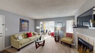 Located at 3100 Long Meadow Ct in Raleigh, NC, this single-floor residence offers a well-designed layout that balances functionality and comfort throughout. The living room serves as the heart of the home, featuring neutral-toned carpet, cool gray walls, and abundant natural light streaming through multiple windows fitted with horizontal blinds. A tile-surround fireplace anchored by a wall-mounted TV and flanked by built-in shelving creates a striking focal point in the main living area. An open passageway connects the living room to a flexible office or study nook, complete with a ceiling fan and access to natural light, making it ideal for remote work or study. The kitchen is outfitted with crisp white cabinetry, light countertops, a gas range, and wood-style flooring, offering a clean and practical cooking space. Adjacent to the kitchen, the dining area provides a dedicated space for meals and entertaining. The bedrooms are carpeted and generously sized, each featuring large windows with views of the surrounding greenery, allowing for ample natural light and a calm, restful atmosphere. Throughout the home, consistent gray tones and textured ceilings contribute to a cohesive and inviting ambiance.