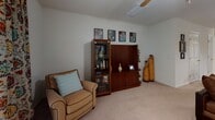 Located at 4024 Kessler Ave in Savannah, Georgia, this two-floor residence offers a thoughtfully designed layout that balances comfort and functionality throughout. The living room provides a welcoming atmosphere with plush carpeted flooring, a ceiling fan, and natural light filtered through drape-adorned windows. Adjacent to the living area, the dining space features a pendant chandelier overhead and an open pass-through to the kitchen, creating a seamless flow for everyday living and entertaining. The kitchen is outfitted with white cabinetry, matching white appliances including a refrigerator, electric range, and built-in microwave, as well as tile flooring and a window that brings in natural light. Each bedroom is carpeted and well-lit, with windows dressed in decorative valances or curtains. The bedrooms offer a calm, neutral aesthetic with ample space for furnishings. A versatile bonus room with carpeting and a ceiling fan provides additional flexible living space ideal for a sitting room or home office. The two full bathrooms each include a tub-shower combination with tiled surrounds and tile flooring, maintaining a clean and practical design. Throughout the residence, neutral wall tones and consistent finishes create a cohesive and inviting ambiance.