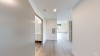 Located at 3803 S Warsaw St in Seattle, WA, this efficiently designed one-bedroom, one-bathroom unit offers a thoughtful layout across a single floor. The interior is finished in a clean, modern aesthetic with light wood-style plank flooring and crisp white walls throughout, creating a bright and cohesive atmosphere.

The kitchen is well-appointed with white shaker-style cabinetry, open shelving, a stainless steel refrigerator, a built-in microwave, an electric cooktop, an under-cabinet range hood, and a single-basin sink — providing all essential amenities in a compact, functional arrangement.

The bedroom is a well-proportioned private retreat featuring a large window with views of the surrounding Seattle neighborhood, flooding the room with natural light. A built-in closet with a hanging rod offers convenient storage.

The bathroom features a clean, minimalist design with wood-look tile flooring, a white floating vanity with an integrated sink, a toilet, and a walk-in shower with a grab bar. The all-white palette keeps the space feeling open and fresh.

A connecting hallway links the rooms seamlessly, contributing to the unit's efficient flow. Multiple windows across the space ensure natural light reaches every corner, enhancing the overall sense of openness in this modern Seattle residence.