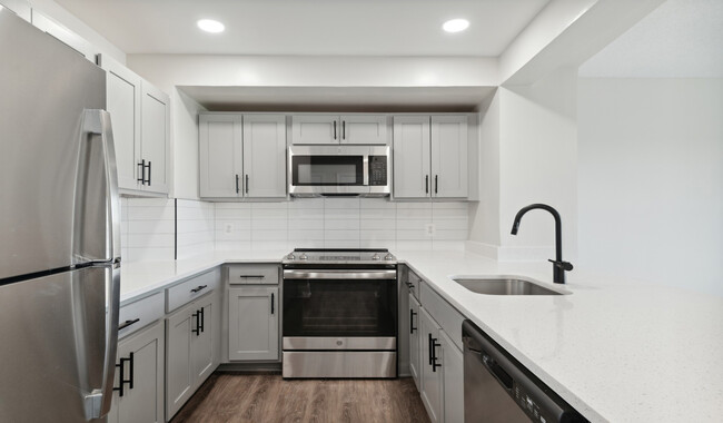 Select homes feature upgraded kitchens with quartz countertops and wood flooring - The Residences at Capital Crescent Trail