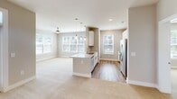 This thoughtfully designed 2-bedroom, 2-bathroom home in Charlotte, NC offers a comfortable and functional single-floor layout. The open-concept living area is anchored by a modern kitchen featuring white cabinetry, subway tile backsplash, granite countertops, stainless steel appliances including a refrigerator with ice maker, and a peninsula with pendant lighting overhead — ideal for both cooking and entertaining. The living area extends toward a glass door that welcomes natural light and provides access to a private balcony.

Both bedrooms are carpeted and finished with neutral tones, offering a calm and restful atmosphere. The generously sized primary bedroom includes a ceiling fan and large windows with exterior views. The primary bathroom is a standout, boasting a dual-sink granite vanity with white cabinetry, hardwood-style flooring, a full-width mirror, and a walk-in glass-enclosed shower. A spacious walk-in closet with wire shelving provides ample storage.

The second bathroom offers additional convenience for guests or residents. A dedicated laundry room with hardwood-style flooring comes equipped with a Whirlpool washer and overhead wire shelving. Throughout the home, clean lines, neutral paint, and white trim create a cohesive, modern aesthetic.