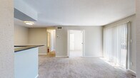 Located at 8380 El Mundo St in Houston, TX, this two-bedroom, two-bathroom residence offers a practical and comfortable single-floor layout. The open living room is carpeted and anchored by a tile-surround fireplace with a white mantel shelf, creating a welcoming focal point. Vertical blinds allow for natural light and privacy. The kitchen is well-appointed with white cabinetry, dark granite countertops, a tile backsplash, stainless steel appliances including a refrigerator, range, and microwave, and durable hardwood-style flooring. A breakfast bar connects the kitchen to the main living area. Both bedrooms are carpeted and feature ceiling fans with lighting and windows that bring in natural light. The primary bedroom includes access to a walk-in closet equipped with wire shelving and organizational racks for ample storage. The bathrooms feature white cabinetry, dark granite countertops, mirrored medicine cabinets, and hardwood-style flooring. Neutral-toned walls and textured ceilings are consistent throughout, contributing to a clean and cohesive aesthetic across the entire residence.