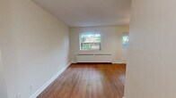 Located at 22 Elkhorn Dr in Toronto's North York neighbourhood, this one-bedroom, one-bathroom unit offers a practical and efficiently designed single-floor layout. Warm hardwood flooring flows throughout the main living areas, complementing the neutral cream-toned walls that lend the space a clean and bright character.

The living area is generously proportioned relative to the overall footprint, featuring a baseboard heating unit beneath a window that frames views of mature greenery outside. A second windowed door provides additional natural light, creating an airy and welcoming atmosphere.

The kitchen has been thoughtfully updated with crisp white shaker-style cabinetry, marble-look countertops, a classic tile backsplash, and a stainless steel electric range with an integrated range hood — offering a modern and functional cooking space.

The bedroom is a cozy, well-defined room with a sliding closet door and the same warm hardwood flooring, providing practical storage and a restful retreat.

The bathroom is finished with classic cream square wall tiles surrounding a full-size soaking tub with overhead shower, offering a clean and timeless aesthetic.

Overall, this unit presents a well-maintained, move-in-ready space with updated finishes, making it a functional and comfortable home in a convenient Toronto location.
