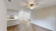 This single-floor, 2-bedroom, 1-bathroom home offers a practical and well-organized layout designed to maximize comfort and usability. The open-concept living and dining area features warm-toned luxury vinyl plank flooring, a ceiling fan with light fixture, and a textured ceiling, creating a bright and airy atmosphere. A peninsular kitchen counter seamlessly connects the living space to the kitchen, which is equipped with stainless steel appliances—including a range, microwave, and refrigerator—white cabinetry, light countertops, and a dedicated pantry closet for added storage.

The primary bedroom is a generously sized retreat featuring sliding glass doors that open to an outdoor space with views of surrounding greenery, a ceiling fan, and its own access to a convenient sink area. The second bedroom offers plush carpeted flooring, a ceiling fan, a window with natural light, and a closet. Both bedrooms maintain a neutral, calming palette throughout.

The full bathroom is clean and functional, featuring a tub-shower combination with brushed nickel fixtures, a white vanity with a quartz-style countertop, and vinyl plank flooring. A dedicated closet provides additional organizational space. The home's consistent neutral tones, updated finishes, and thoughtful layout make it a comfortable and move-in-ready living space.