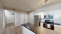 Located in Phoenix, AZ, this single-floor, 2-bedroom, 1-bathroom residence offers a well-designed layout that maximizes functionality and comfort. The kitchen is a standout feature, outfitted with stainless steel appliances including a refrigerator, electric range, and built-in microwave. White shaker-style cabinetry lines the walls, complemented by a hexagonal tile backsplash and dark countertops that extend to a peninsula, providing additional prep and dining space. Light wood-style flooring runs through the main living areas, adding warmth and continuity throughout. The living and dining areas are bright and open, with a sliding glass door that invites natural light and provides outdoor access. Ceiling fans are installed throughout, keeping the space comfortable in the Arizona climate. Both bedrooms are carpeted and feature ceiling fans, vertical blinds on the windows, and access to closet storage. The primary bedroom is a comfortable size with its own dedicated closet. The bathroom is finished with wood-style flooring, a white vanity with dark countertop, a framed mirror, and clean, neutral tones. Overall, the space presents a clean, modern aesthetic with practical finishes suited for everyday living.