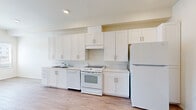 Located at 2040 Transit Guideway in Chula Vista, CA, this thoughtfully designed one-bedroom, one-bathroom unit offers a clean, modern aesthetic throughout its single-floor layout. Light-toned wood-look flooring runs continuously across all rooms, lending a cohesive and airy feel to the space.

The kitchen is a standout feature, outfitted with crisp white shaker-style cabinetry extending to the ceiling for ample storage. White appliances — including a refrigerator, electric range, and dishwasher — complement the light countertops and recessed lighting overhead. The kitchen flows openly into the main living area, which benefits from recessed lighting and a welcoming entry door.

The bedroom is a comfortable, well-proportioned room featuring a large window that allows natural light to fill the space. A sliding double-door closet provides generous storage, while the neutral white walls and wood-look flooring maintain the unit's clean, modern character.

The bathroom is spacious and accessibility-conscious, equipped with stainless steel grab bars, a fold-down shower seat, and wood-look flooring that echoes the rest of the unit. The layout prioritizes ease of use and practicality. Overall, this unit presents a bright, functional, and move-in-ready living space in a well-located Chula Vista community.