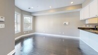 Located on New Jersey Avenue NW in Washington, DC, this two-floor home offers a well-designed layout spread across two evenly sized levels. The main floor welcomes you through a classic paneled front door with a transom window, opening into a bright living area with rich dark hardwood floors and neutral gray walls that carry throughout the space. Recessed lighting and multiple windows allow natural light to flow freely, framing views of the surrounding neighborhood.

The kitchen is a functional highlight, featuring white shaker cabinetry reaching toward the ceiling, dark stone countertops, and a full suite of stainless steel appliances including a gas range, built-in microwave, dishwasher, and refrigerator. A peninsula provides additional prep space and connects seamlessly to the dining area. A dark-stained staircase with an elegant wrought iron railing leads to the upper level.

Upstairs, the spacious primary bedroom is carpeted and bathed in natural light through well-sized windows offering outdoor views. The home includes three bathrooms, one featuring classic octagonal tile flooring and a soaking tub with white subway tile surround. Additional highlights include five closets, a dedicated laundry area, and two hallways that ensure smooth circulation throughout both floors.