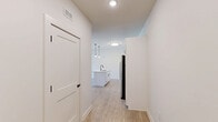 Located at 610 Sugar Pine Way in Wake Forest, NC, this single-story, one-bedroom, one-bathroom home offers a thoughtfully designed layout with modern finishes throughout. The open-concept living and kitchen area serves as the heart of the home, anchored by a large center island with a white quartz countertop and matte black undermount sink. Crisp white shaker cabinetry with black hardware lines the kitchen walls, complemented by a white subway tile backsplash and a full suite of stainless steel appliances, including a French door refrigerator, electric range, built-in microwave, and dishwasher. Stylish pendant lighting with Edison bulbs hangs above the island, adding a contemporary touch. Light wood-look flooring extends through the main living areas, enhancing the bright and airy atmosphere. The living area features a ceiling fan and large windows that invite natural light and outdoor views. The spacious bedroom is carpeted for comfort, includes a ceiling fan, a closet with a rod, and a window with neighborhood views. The bathroom is clean and functional, offering a tub/shower combination, light wood-look flooring, and a bright white palette with matte black accents throughout.