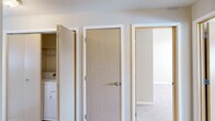 Located in Airway Heights, WA, this 2-bedroom, 1-bathroom residence offers a thoughtfully organized single-floor layout designed for comfortable everyday living. The kitchen features light wood cabinetry, laminate countertops, a white electric range, a full-size refrigerator, and wood-style flooring. A peninsula counter with additional workspace opens toward the main living area, enhancing the flow between spaces. The living room is carpeted and bright, highlighted by a sliding glass door that leads to a private balcony with views of the surrounding neighborhood and fills the room with natural light. A wall-mounted air conditioning unit provides climate control. Both bedrooms are carpeted and finished with neutral tones; the primary bedroom is generously sized with a dedicated closet, while the second bedroom features a large window that invites natural light. A hallway connects the main areas and includes an in-unit washer and dryer closet, adding everyday convenience. The full bathroom offers a tub-shower combination, a single vanity with storage, and wood-style flooring. Throughout the residence, a clean, neutral color palette and consistent finishes create a cohesive and functional living environment.