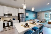 Located at 89 Hopkins Street in Wakefield, MA, this thoughtfully designed one-bedroom, one-bathroom residence offers a comfortable and stylish single-floor layout. The open-concept kitchen and living area serves as the heart of the home, featuring crisp white shaker cabinetry, a light gray subway tile backsplash, stainless steel appliances, and a white quartz-topped center island with pendant lighting and seating — ideal for casual dining or entertaining. Light wood-style flooring runs throughout the main living area, adding warmth and continuity. The living room is anchored by a bold teal accent wall, recessed lighting, and a sliding glass door that opens to a private balcony with outdoor views. The spacious primary bedroom features plush carpeting, large windows with natural light, a teal accent wall, and a dedicated closet for ample storage. The full bathroom is finished with tile flooring and a full-size soaking tub and shower combination. A dedicated dining area provides additional flexibility between the kitchen and living spaces. Throughout the residence, a neutral yet vibrant color palette, modern fixtures, and clean architectural lines create a cohesive and inviting atmosphere well-suited for contemporary living in the greater Boston area.