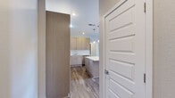 This single-floor residence at 3317 Syracuse St in Denver's Central Park neighborhood offers a thoughtfully designed, modern living environment. The kitchen is a standout feature, showcasing flat-front cabinetry in a warm taupe finish, a classic white subway tile backsplash, stainless steel appliances including a refrigerator, range, microwave, and dishwasher, and a large center island with quartz countertops illuminated by pendant lighting. Durable wood-look flooring runs throughout the main living areas, complementing the neutral color palette. The open-concept layout connects the kitchen seamlessly to the living and dining area, which is brightened by large windows and a sliding glass door opening to a private balcony with neighborhood views. The bedrooms are generously sized, finished with plush carpeting, large windows that invite natural light, and ample closet space, including a walk-in closet with wire shelving and hanging rods. The bathroom features a full tub and shower combination with a two-tone tile surround, a vanity with quartz countertop, and tile flooring. Clean lines, neutral tones, and modern finishes throughout create a cohesive and contemporary ambiance.