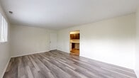 Located at 80 W Mill St in Springboro, Ohio, this single-floor residence offers three bedrooms, one bathroom, a kitchen, and a closet within a well-organized layout. Consistent grey-toned luxury vinyl plank flooring runs throughout the entire unit, providing a clean, cohesive aesthetic from room to room.

The spacious primary bedroom is notably generous in size, featuring a large sliding-door closet and access to the full bathroom, which is equipped with a tub-shower combination, a single vanity with wood cabinetry, and a wall mirror. The two additional bedrooms are bright and comfortable, each featuring windows that allow natural light and views of the surrounding greenery.

The galley-style kitchen is efficiently designed with dark wood cabinetry lining both walls, white countertops, a double sink, and white appliances including an electric range and refrigerator. An overhead range hood and ceiling light fixture complete the functional cooking space.

Throughout the unit, neutral cream-toned walls complement the flooring, creating a bright and airy atmosphere. The floor plan, as shown in the dollhouse view, reflects a straightforward and practical layout that maximizes the use of available space. This unit offers a comfortable and move-in ready living environment in Springboro, OH.