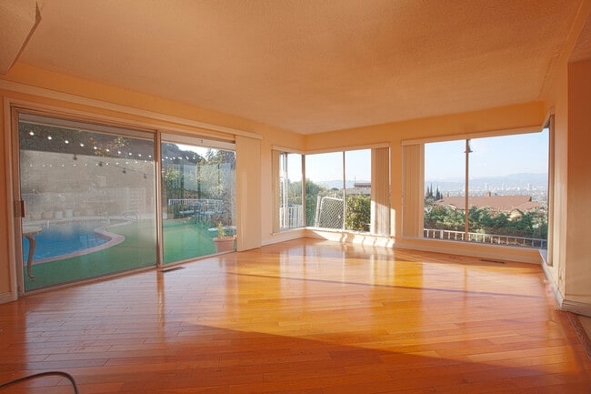 Amplia sala familiar con pisos de madera y ventanas con vista de piso a techo. - 3903 Carol Court
