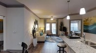 Located at 3101 Rise Dr in Morrisville, NC, this single-floor residence offers a thoughtfully designed open-concept layout that seamlessly connects the kitchen and living areas. Rich hardwood-style flooring flows throughout the main living space, adding warmth and visual continuity. The kitchen features striking granite countertops and a breakfast bar with seating, complemented by a stylish pendant light that anchors the space with a modern touch. Crown molding trims the ceilings, adding an elegant architectural detail throughout. The living area is bright and inviting, bathed in natural light from multiple large windows and glass French doors that open to the outdoors, creating a seamless indoor-outdoor connection. A ceiling fan with light fixture enhances comfort and airflow in the main living room. The space is designed with generous proportions, offering room for comfortable furniture arrangements and tasteful décor. Neutral wall tones provide a versatile backdrop, while the overall ambiance is warm, welcoming, and move-in ready. This well-appointed single-level home balances style and functionality in a desirable Morrisville location.