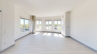This well-appointed 3-bedroom, 2-bathroom residence in Arlington Heights, IL offers a thoughtfully designed modern interior with clean lines and a bright, contemporary aesthetic throughout. Light hardwood-style flooring flows through the open-concept living and dining area, which is anchored by expansive floor-to-ceiling windows and exposed concrete columns that add an industrial architectural touch. The abundance of natural light and open sightlines create a spacious, airy atmosphere. The living area provides direct access to a generously sized outdoor terrace with tile flooring and wrought-iron railings, offering sweeping views of the surrounding green landscape and skyline. The kitchen features quartz countertops, a stainless steel refrigerator, subway tile backsplash, and two-tone cabinetry in white and warm wood tones. The primary bathroom is finished with a double-sink vanity with dark wood cabinetry, backlit mirrors, and a glass-enclosed walk-in shower with white tile surround. The three bedrooms are well-proportioned, each with light flooring and ample closet space—including a dedicated walk-in closet with built-in shelving and hanging rods. Every room reflects a cohesive, modern design sensibility suited for contemporary living.