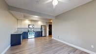 Located at 710 N College Ave in Bloomington, Indiana, this well-appointed three-bedroom, three-bathroom unit offers a functional and comfortable single-floor layout. The open-concept kitchen and living area serves as the heart of the home, featuring hardwood-style plank flooring, a ceiling fan, and recessed lighting with a tray ceiling detail. The kitchen is equipped with stainless steel appliances — including a refrigerator, range, microwave, and dishwasher — complemented by two-tone cabinetry with dark lower cabinets and white uppers, topped with granite-style countertops. The three bedrooms offer a mix of hardwood-style and carpeted flooring, each with windows that bring in natural light and views of the surrounding neighborhood. The three bathrooms are finished with classic black-and-white octagon tile flooring, dark vanity cabinetry, white countertops, and full tub-shower combinations. A dedicated in-unit laundry room accommodates a full-size washer and dryer with an overhead storage shelf. A carpeted hallway connects the bedrooms and bathrooms, while two closets provide additional storage. The overall aesthetic is clean and modern, with neutral tones throughout creating a cohesive and move-in-ready environment.