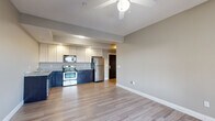 Located at 710 N College Ave in Bloomington, Indiana, this well-appointed three-bedroom, three-bathroom unit offers a functional and comfortable single-floor layout. The open-concept kitchen and living area serves as the heart of the home, featuring hardwood-style plank flooring, a ceiling fan, and recessed lighting with a tray ceiling detail. The kitchen is equipped with stainless steel appliances — including a refrigerator, range, microwave, and dishwasher — complemented by two-tone cabinetry with dark lower cabinets and white uppers, topped with granite-style countertops. The three bedrooms offer a mix of hardwood-style and carpeted flooring, each with windows that bring in natural light and views of the surrounding neighborhood. The three bathrooms are finished with classic black-and-white octagon tile flooring, dark vanity cabinetry, white countertops, and full tub-shower combinations. A dedicated in-unit laundry room accommodates a full-size washer and dryer with an overhead storage shelf. A carpeted hallway connects the bedrooms and bathrooms, while two closets provide additional storage. The overall aesthetic is clean and modern, with neutral tones throughout creating a cohesive and move-in-ready environment.