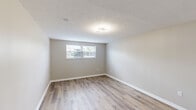 Located at 4646 Tamarack Blvd in Columbus, OH, this single-floor 1-bedroom, 1-bathroom unit offers a thoughtfully updated interior with a clean, modern aesthetic throughout. The space features luxury vinyl plank flooring in a warm wood tone that flows consistently through the living areas, hallways, and bedroom, complemented by neutral gray-beige walls and crisp white trim.

The kitchen is a standout feature, showcasing white shaker-style cabinetry with matte black hardware, light granite countertops, a black undermount sink with a modern faucet, and black appliances including a refrigerator and electric range with an overhead exhaust hood. The layout maximizes efficiency while maintaining a fresh, contemporary feel.

The bedroom offers a comfortable footprint with a textured ceiling, a modern flush-mount light fixture, and a window that allows natural light to filter in. The hallways connect the rooms with ease, with one hallway featuring an electrical panel access point and recessed lighting.

The bathroom is neatly appointed with a white vanity, a tub/shower combo with clean white surround, and wood-look flooring that carries the cohesive design forward. A utility room rounds out the layout, adding practical storage and functional space. Overall, this unit presents a well-maintained, move-in-ready interior with consistent modern updates throughout.