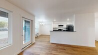 Located at 50 Market St in Lebanon, Oregon, this 2-bedroom, 2-bathroom unit offers a clean, modern design across a single floor. Warm wood-look flooring flows consistently throughout every room, creating a cohesive and inviting atmosphere. The kitchen and living area form an open, functional layout anchored by white shaker-style cabinetry, dark granite-style countertops, a kitchen island, and black appliances including a range and refrigerator. Recessed lighting and a chandelier accent the kitchen and living space. Both bedrooms feature bright windows with horizontal blinds that invite natural light and provide views of the surrounding neighborhood. The primary bedroom offers a comfortable, well-proportioned layout. Each bathroom is finished with wood-look flooring, white cabinetry with dark countertops, and chrome fixtures. One bathroom includes a walk-in shower with a grab bar, while the second features a full shower-tub combination. The unit's crisp white walls, clean lines, and consistent finishes throughout give the space a fresh, move-in-ready feel well-suited for everyday living in Lebanon, Oregon.