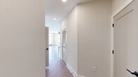 Located at 400 Universal Rd in Southern Pines, NC, this well-appointed 2-bedroom, 2-bathroom residence offers a thoughtfully designed single-floor layout with modern finishes throughout. The open-concept kitchen and living area serves as the heart of the home, featuring a large central island with white quartz countertops, white upper shaker cabinets, light gray lower cabinetry, a subway tile backsplash, stainless steel appliances, and matte black hardware. Pendant lighting above the island adds a contemporary touch. Warm wood-look flooring flows seamlessly throughout the entire residence, complementing the neutral, light-toned walls. Both bedrooms are generously proportioned and filled with natural light from large windows fitted with blinds. Ceiling fans with integrated lighting are present in each bedroom. Each room also benefits from dedicated closet space. The primary bathroom features a sleek walk-in shower enclosed by a frameless glass door with matte black trim and fixtures. The second bathroom offers a full tub-shower combo with white tile surround, a vanity with white countertop, and coordinating matte black fixtures. Recessed lighting and clean white trim complete the polished, move-in-ready aesthetic of this Southern Pines residence.
