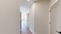 Located at 400 Universal Rd in Southern Pines, NC, this well-appointed 2-bedroom, 2-bathroom residence offers a thoughtfully designed single-floor layout with modern finishes throughout. The open-concept kitchen and living area serves as the heart of the home, featuring a large central island with white quartz countertops, white upper shaker cabinets, light gray lower cabinetry, a subway tile backsplash, stainless steel appliances, and matte black hardware. Pendant lighting above the island adds a contemporary touch. Warm wood-look flooring flows seamlessly throughout the entire residence, complementing the neutral, light-toned walls. Both bedrooms are generously proportioned and filled with natural light from large windows fitted with blinds. Ceiling fans with integrated lighting are present in each bedroom. Each room also benefits from dedicated closet space. The primary bathroom features a sleek walk-in shower enclosed by a frameless glass door with matte black trim and fixtures. The second bathroom offers a full tub-shower combo with white tile surround, a vanity with white countertop, and coordinating matte black fixtures. Recessed lighting and clean white trim complete the polished, move-in-ready aesthetic of this Southern Pines residence.