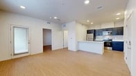 Located at 2525 S Meadows Rd in Santa Fe, New Mexico, this single-floor, one-bedroom, one-bathroom unit offers a well-organized and efficiently designed layout. Light wood-style flooring flows consistently throughout the space, lending a clean, cohesive aesthetic.

The open-concept kitchen and living area serves as the heart of the unit. The kitchen is outfitted with dark navy cabinetry contrasted by crisp white countertops, a subway tile backsplash, and a full suite of stainless steel appliances including a refrigerator, electric range, and microwave. A peninsula with an integrated sink provides additional prep space and casual seating potential. A dedicated pantry offers extra storage convenience.

The living area is bright and airy, with recessed lighting and access to a private patio through a glass door, allowing natural light to fill the space. The bedroom is a comfortable, well-proportioned room featuring a ceiling fan, a window with natural light, and access to a closet. 

The bathroom includes a full tub-shower combination, a dark-vanity with a white countertop and sink, and a large mirror. A dedicated laundry area rounds out the functional amenities of this unit, making it a practical and modern home in Santa Fe.