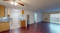 Located at 543 N Madison Ave in the heart of Los Angeles, this single-floor unit offers a practical and comfortable layout throughout. The open living area makes an immediate impression with its rich, dark hardwood flooring and a ceiling fan overhead. A sliding glass door floods the space with natural light and provides access to an outdoor view, enhancing the airy feel of the room. The galley-style kitchen is efficiently designed with ample oak cabinetry on both sides, granite-look countertops, a double basin sink, a gas range, and a full-size refrigerator, all set on light wood-look flooring. The living and kitchen areas flow seamlessly together, creating a connected, open atmosphere. The bedrooms are carpeted for comfort and feature large windows with vertical blinds that invite natural light while maintaining privacy. Each bedroom offers generous proportions and direct access to the rest of the unit. Two bathrooms serve the space: one features tile flooring, a combined shower and tub enclosure with glass sliding doors, and a window for ventilation; the second includes a vanity with under-sink storage, a mirror, tile flooring, and a side window. The overall aesthetic is clean and neutral, providing a versatile canvas throughout.