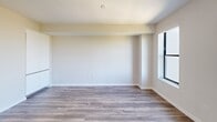 Located at 500 N Andrews Ave in Fort Lauderdale, FL, this modern studio unit offers a thoughtfully designed single-floor layout that maximizes functionality. The open-concept kitchen and living area serves as the heart of the space, featuring sleek, floor-to-ceiling white cabinetry, a marble-style tile backsplash, stainless steel appliances including a range, over-the-range microwave, and dishwasher, and a contemporary countertop with an undermount sink. Wood-style flooring runs throughout, lending warmth to the clean, modern aesthetic. The living area is bright and airy, with large black-framed windows and a sliding glass door that opens to a private balcony, offering sweeping views of the Fort Lauderdale skyline and lush palm-lined surroundings. Natural light fills the space generously throughout the day. The bathroom is finished to a high standard, showcasing marble-look tile flooring, a frameless glass walk-in shower with coordinating wall tile, a backlit vanity mirror, and a white quartz countertop with an undermount sink set atop a wood-toned vanity. A dedicated closet and hallway provide additional storage and connectivity within the unit. The overall ambiance is clean, contemporary, and well-appointed.