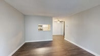 Located at 2275 S Bascom Ave in San Jose, CA, this one-bedroom, one-bathroom residence offers a well-organized single-floor layout designed for efficient, comfortable living. The living room is finished with rich, dark hardwood-style flooring, neutral gray walls, and a textured ceiling. A built-in pass-through window connects the living area directly to the kitchen, enhancing the open feel of the space. A ceiling fan is centrally positioned to provide airflow throughout the main living and dining area.

The kitchen is thoughtfully appointed with white cabinetry, light countertops, and stainless steel appliances including a refrigerator, dishwasher, electric range, and over-the-range microwave. Hardwood-style flooring continues through the kitchen, which also benefits from a ceiling fan and recessed lighting.

The bedroom offers a comfortable footprint with soft carpeting, neutral walls, a textured ceiling, and a large sliding-door closet for ample storage. A window provides natural light and an outdoor view of the surrounding greenery.

The bathroom is clean and functional, featuring hardwood-style flooring, a shower/tub combination, and crisp white finishes throughout. A wall-mounted HVAC unit serves the living area, rounding out the practical amenities of this well-maintained San Jose residence.
