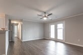 Located at 400 Eden Roc Circle in Virginia Beach, Virginia, this single-floor residence offers a well-designed layout with a cohesive blend of comfort and functionality. The open-concept living area is finished with warm hardwood-style flooring and features crown molding, a ceiling fan, and a set of French doors that invite natural light and provide access to the outdoors. A fireplace mantel adds a classic touch to the main living space.

The kitchen is efficiently designed in a galley-style layout, showcasing white cabinetry, granite-look countertops, and a full suite of stainless steel appliances, including a refrigerator, microwave, and range. The kitchen opens to the main living area via a breakfast bar peninsula, enhancing the sense of openness.

The bedrooms are carpeted for comfort, with soft neutral tones and ample natural light provided by large windows with blinds. One bedroom includes a walk-in closet, while another offers direct access to an en-suite bathroom featuring a vanity with storage and a toilet. A full bathroom with a soaking tub, hardwood-style flooring, and grab bars is also present.

A dedicated laundry area houses a full-size washer and dryer. Throughout, the space is finished in soft gray tones with clean white trim, creating a bright and welcoming atmosphere.