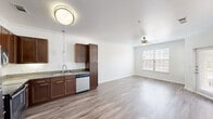 Located at 9520 Spectrum Dr in Austin, TX, this single-story, one-bedroom, one-bathroom residence offers a thoughtfully designed layout. The open-concept living and kitchen area forms the heart of the home, bathed in natural light from multiple windows fitted with blinds. Ceiling fans are present throughout, enhancing comfort and airflow. Hardwood-style flooring runs continuously across all areas, lending a clean, cohesive look.

The kitchen is well-equipped with rich, dark-toned cabinetry, granite countertops, stainless steel appliances including a refrigerator, range, microwave, and dishwasher, along with a double-basin sink and pendant lighting. Crown molding in the living area adds a refined architectural detail.

The spacious bedroom features vaulted ceilings, a ceiling fan, and natural light from a large window. It connects directly to a dedicated closet with built-in shelving, offering generous storage. The bathroom is finished with granite countertops, dark cabinetry, a tile-surround shower, and hardwood-style flooring that continues from the rest of the home.

The entry door includes a sidelight window, welcoming natural light into the main living space. Overall, the residence presents a bright, clean, and functional living environment in the Spectrum Dr corridor of Austin.