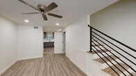 This well-appointed two-story home in Gonzales, Louisiana offers 2 bedrooms and 2.5 bathrooms, thoughtfully designed with modern finishes throughout. The main level features an open layout with light-toned luxury vinyl plank flooring, recessed lighting, and ceiling fans that contribute to a bright, comfortable atmosphere. Natural light filters in through blinded windows, enhancing the clean, neutral color palette of the interior.

The kitchen is a functional highlight, outfitted with gray shaker-style cabinetry, crisp white countertops, a stainless steel undermount sink, and a full suite of stainless steel appliances including a range, over-the-range microwave, and dishwasher. A staircase with a sleek black horizontal-rail railing connects the main level to the upper floor, adding a contemporary architectural touch.

Upstairs, the bedrooms are comfortably sized, each with ceiling fans, natural light from windows, and continued luxury vinyl plank flooring. Each bedroom benefits from convenient access to a private bathroom, finished with gray vanity cabinetry, white countertops, and tile flooring. A half bathroom on the main level provides added convenience for guests. The overall design is clean and modern, making this a well-equipped, move-in-ready home.