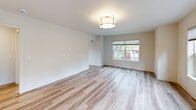 Located at 15948 Quarry Rd in Lake Oswego, Oregon, this 2-bedroom, 1-bathroom apartment offers a thoughtfully designed single-floor layout with modern finishes throughout. Light-toned wood-look flooring flows seamlessly across every room, creating a cohesive and contemporary feel.

The open-concept kitchen and living area serves as the heart of the unit. The kitchen is appointed with rustic wood-grain cabinetry, a subway tile backsplash, stainless steel appliances including a refrigerator, microwave, and range, and a granite-topped peninsula with an undermount sink and pendant lighting overhead. The adjacent living room is bright and spacious, featuring a wide bank of windows with cellular shades that frame views of the surrounding greenery.

Both bedrooms are well-proportioned and filled with natural light from generously sized windows. The primary bedroom includes a sliding double-door closet, while the second bedroom also offers window views of the tree-lined surroundings. The full bathroom is clean and functional, featuring a wood-toned vanity and a window for natural ventilation. A connecting hallway ties all rooms together efficiently. The unit's neutral color palette and modern fixtures create a fresh, move-in-ready atmosphere throughout.