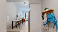 This thoughtfully designed single-floor residence offers four bedrooms and three bathrooms within a compact yet efficiently utilized footprint. The open-plan living and dining area anchors the space, featuring impressively tall ceilings, light wood flooring, and track lighting that enhances the airy ambiance. A streamlined kitchen with white cabinetry and stainless steel appliances integrates seamlessly into the main living area. Large floor-to-ceiling glass doors in the living room flood the space with natural light and provide direct access to a private outdoor area. The bedrooms are cozy and well-appointed, each with light-toned walls, wood flooring, and windows that invite natural light. Three dedicated closets offer practical storage throughout. The three bathrooms are a standout feature, each finished with distinctive geometric patterned tile wainscoting in soft blue and white tones, complemented by checkerboard tile flooring. Each bathroom includes either a shower-tub combination or a walk-in shower enclosed in glass, along with clean white vanities. The overall design aesthetic is modern and contemporary, with a neutral color palette accented by warm wood tones, creating a cohesive and functional living environment.