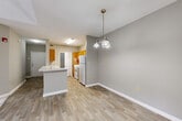 Located at 717 Burns Rd in Carrollton, Georgia, this single-story, 3-bedroom, 2-bathroom home offers a functional and well-organized layout. The interior is finished with neutral gray walls and wood-look flooring throughout the main living areas, creating a clean and cohesive aesthetic.

The kitchen is a standout feature, equipped with warm honey-toned wood cabinetry, a white electric range, a full-size refrigerator, and an under-cabinet range hood. A peninsula with a light-colored countertop and double sink extends into the dining area, which is accented by a decorative pendant chandelier — ideal for casual dining and entertaining.

A central hallway connects the main living areas to the three bedrooms and two bathrooms, maintaining a logical flow throughout the home. The bedrooms feature plush wall-to-wall carpeting; the spacious primary bedroom includes a door leading to an outdoor area and a window allowing natural light to filter in. Additional bedrooms are bright and well-proportioned, each with windows and ceiling fans.

The bathrooms are finished with wood-toned vanity cabinetry, light quartz-style countertops, and tile-surround tub/shower combinations. Each bedroom is accompanied by a dedicated closet, offering ample storage. The home's simple, practical design makes it a comfortable and move-in-ready residence.