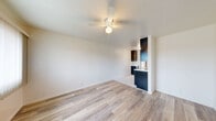 Located at 1231 Persimmon Avenue in El Cajon, CA, this one-bedroom, one-bathroom unit offers a thoughtfully designed and efficiently utilized floor plan across a single level. Light wood-look flooring flows throughout the main living areas, creating a cohesive and bright aesthetic. The open living area features crisp white walls and a ceiling fan, contributing to an airy and comfortable atmosphere.

The kitchen is a standout feature, finished with sleek dark cabinetry that contrasts boldly against light tile flooring and marble-look countertops. It is equipped with black appliances including a range, microwave, and refrigerator, along with ample upper and lower cabinet storage. A passthrough view connects the kitchen to the living and dining area, enhancing the sense of openness.

The bedroom is well-proportioned, benefiting from a large window that invites natural light and neighborhood views. A ceiling fan adds comfort, and a wall-mounted AC unit provides climate control. The room also includes a dedicated closet area with built-in wire shelving for organized storage.

The bathroom is designed with accessibility in mind, featuring a walk-in shower equipped with a grab bar, handheld showerhead, and a shower chair. The clean white finish of the shower enclosure gives the space a tidy, functional feel throughout.