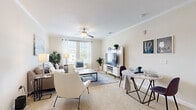 Located in Orlando's Lake Nona area, this single-floor, 2-bedroom, 2-bathroom residence offers a thoughtfully designed open-concept layout. The entryway, framed by an elegant arch, leads into a bright, combined living, dining, and kitchen area. Rich hardwood-style flooring flows through the main living spaces, while crown molding and ceiling fans add a refined touch throughout.

The kitchen is a standout feature, boasting dark espresso cabinetry, stainless steel appliances, under-cabinet lighting, and a generous granite-topped breakfast bar ideal for casual dining. The adjoining living and dining area is bathed in natural light from multiple windows and offers ample room for relaxed living and entertaining.

Both bedrooms are carpeted and serene, with the spacious primary bedroom featuring a large window with outdoor views and generous closet space. The second bedroom is equally comfortable. Each of the two bathrooms is finished with dark vanity cabinetry, granite countertops, hardwood-style flooring, and a tub-shower combination. A dedicated laundry area and three closets add practical convenience. The neutral warm tones and clean lines throughout create a bright, welcoming ambiance.