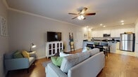 This single-floor residence at 1029S S Maestri Road in Tontitown, Arkansas, offers a thoughtfully designed layout that balances comfort and functionality. The open-concept living area serves as the heart of the home, showcasing warm hardwood-style flooring, crown molding, and ceiling fans throughout. Recessed lighting and natural light from large windows contribute to a bright, welcoming ambiance. French doors in the living area open to a private balcony, providing pleasant outdoor views.

The kitchen is well-equipped with crisp white shaker-style cabinetry, dark granite countertops, stainless steel appliances, and a peninsula with bar seating. Light tile flooring ties the kitchen seamlessly to the adjacent dining area, making it an ideal space for cooking and entertaining.

Both bedrooms are generously sized, featuring plush carpeting, ceiling fans, and multiple windows that invite natural light. Each bathroom includes a tub-shower combination with brushed nickel fixtures. One bathroom features a dark granite vanity countertop with white cabinetry, while the second offers a clean, functional design with contemporary finishes. The overall aesthetic is modern, cohesive, and move-in ready.
