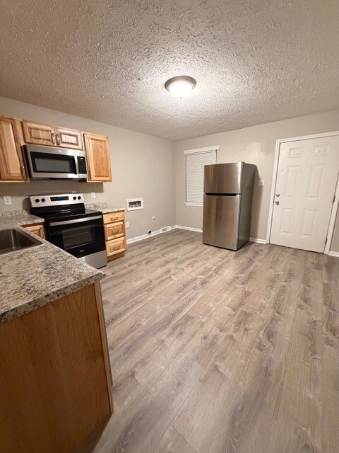 Vista de la cocina desde un ángulo opuesto, con las conexiones para el refrigerador y la lavadora/secadora. - 3203 Island Rd