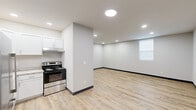 Located at 855 Louisville Rd in Frankfort, Kentucky, this efficiently designed single-floor unit offers a clean, modern aesthetic well-suited for comfortable everyday living. The open-concept layout integrates the living area and kitchenette into one cohesive space, maximizing functionality within a compact footprint. Light wood-tone vinyl plank flooring runs throughout, complemented by crisp white walls, dark baseboard trim, and recessed LED lighting that keeps the interior bright and welcoming. The kitchenette is equipped with white cabinetry, an electric range with a stainless steel finish, a refrigerator, and an under-cabinet range hood, providing essential cooking amenities. The spacious open living area offers flexibility for furniture arrangement and benefits from a window that introduces natural light. A gray entry door provides a clean, secure point of access. The full bathroom is thoughtfully appointed with a white vanity featuring a marble-style countertop and brushed nickel hardware, a full-size soaking tub with shower, a toilet, and matching wood-tone flooring that ties seamlessly into the rest of the unit. Overall, the space presents a freshly finished, move-in-ready environment with a consistent and contemporary design palette throughout.