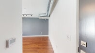 Located in the heart of Memphis, TN, this one-bedroom, one-bathroom unit at The Rock N' Soul offers a well-designed layout with modern industrial touches. Warm hardwood flooring flows throughout the entire space, complementing the clean white walls and creating a cohesive, inviting atmosphere.

The open living area features exposed silver ductwork along the ceiling, adding an urban, loft-inspired character. Track lighting illuminates the space, while a ceiling fan provides year-round comfort. The kitchen is efficiently appointed with rich, dark wood cabinetry, granite countertops, and a full suite of stainless steel appliances including a refrigerator, electric range, built-in microwave, and dishwasher. A window brings in natural light, enhancing the kitchen's functional design.

The bedroom is a generously sized retreat, benefiting from large windows with blinds that invite natural light while maintaining privacy. A ceiling fan adds comfort to this well-proportioned room.

The bathroom mirrors the quality finishes found throughout, featuring a granite-topped vanity with dark wood cabinetry, a tub-shower combination, and hardwood-style flooring. A convenient in-unit washer and dryer are tucked neatly within the bathroom, adding practical everyday functionality to this thoughtfully designed Memphis residence.