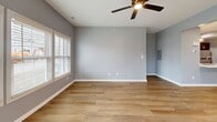 Located at 3385 Cedar Valley Way in Hamburg, NY, this well-appointed 2-bedroom, 1-bathroom home offers a thoughtfully designed single-floor layout with a clean, contemporary aesthetic throughout. Consistent light hardwood-style flooring flows across the living spaces, complemented by cool gray walls and crisp white trim that create a bright, cohesive atmosphere.

The combined kitchen and living room serves as the heart of the home. The kitchen is outfitted with rich dark gray shaker-style cabinetry, white countertops, and a full suite of stainless steel appliances including a gas range, over-the-range microwave, and refrigerator. Recessed lighting and ample cabinet storage make this a highly functional cooking space.

The spacious primary bedroom features natural light from a double window with blinds and a ceiling fan overhead. The second bedroom is equally well-sized and similarly finished, providing versatile use of space. Both rooms are served by two closets — including a walk-in closet equipped with wire shelving systems for organized storage.

The bathroom features a clean tub/shower combo with brushed nickel fixtures set against bright white surround walls. Two hallways connect the rooms efficiently. An attached garage with an automatic opener rounds out this practical and modern home.