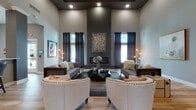 Located at 5101 Magnolia Lake Dr. in Westerville, Ohio, this single-story community clubhouse delivers a refined and welcoming environment designed for both relaxation and productivity. The grand entrance greets visitors with light wood-look flooring, oversized glass doors, and abundant natural light that flows throughout the space.

The centerpiece of the clubhouse is a dramatic lounge area boasting soaring double-height ceilings with a striking coffered detail, a sleek linear fireplace set against a dark accent wall, and large windows framed by floor-to-ceiling drapes. Sophisticated seating arrangements — including tufted sofas and nailhead-trim accent chairs — create an inviting, upscale atmosphere.

Adjacent gathering areas offer additional flexible seating with warm wood-tone floors and curated artwork. A dedicated conference room features a large dark wood table, upholstered chairs, a wall-mounted display, and an elegant chandelier overhead. A private office or leasing area provides a glass-top table and ample natural light through full-length windows.

The catering kitchen is well-appointed with dark lower cabinetry, white quartz countertops, an under-mount sink, and wall-mounted displays — ideal for community events. The fitness area is equipped with medicine balls, a barn-style storage door, ceiling fan, and open floor space for varied workouts. Together, these amenities form a cohesive, thoughtfully designed community hub.