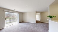 Located at 12914 Falling Water Circle in Germantown, Maryland, this single-floor, 2-bedroom, 2-bathroom residence offers a well-organized layout with consistent neutral finishes throughout. The open living room serves as the central gathering space, finished with plush carpeting and warm beige walls. Sliding glass doors lead to a private balcony, allowing natural light to fill the room and providing views of the surrounding outdoor greenery.

The galley-style kitchen is efficiently designed, featuring light wood cabinetry, white laminate countertops, a stainless steel sink, and wood-look vinyl flooring. Standard appliances including an electric range, refrigerator, and dishwasher are included.

A hallway connects the living area to both bedrooms and bathrooms. The primary bedroom is a comfortable size, carpeted, and includes a closet, while a large window draws in ample natural light. The second bedroom similarly features carpeting, a closet, and direct outdoor views. Both bathrooms are equipped with vanities featuring wood cabinetry and light countertops. One bathroom includes a tub-shower combination with tile surround, while the other features a shower with curtain enclosure. The layout is practical and cohesive throughout.