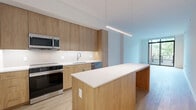 Located at 4909 Auburn Ave, Unit 210 in Bethesda, MD, this thoughtfully designed 2-bedroom, 2-bathroom residence offers a clean, contemporary aesthetic throughout. The open-concept kitchen serves as the heart of the home, showcasing warm wood cabinetry that extends to the ceiling, a large waterfall-edge island with pendant lighting, white quartz countertops, a crisp tile backsplash, and a full suite of stainless steel appliances including a French door refrigerator, electric range, microwave, and dishwasher. Light hardwood flooring runs throughout the living areas and bedrooms, lending warmth and continuity to the space. The primary bedroom is generously proportioned and benefits from floor-to-ceiling windows that invite abundant natural light. The en-suite primary bathroom features a dual-sink vanity with wood cabinetry, white quartz countertops, large-format tile flooring, and a glass-enclosed walk-in shower with marble-style tile surround. The second bedroom offers a stylish frosted-glass sliding barn door and its own access to a hallway. Three closets provide ample storage throughout the unit. The overall ambiance is modern and minimalist, with a neutral palette, clean lines, and high-quality finishes that reflect a refined urban lifestyle in the heart of Bethesda.